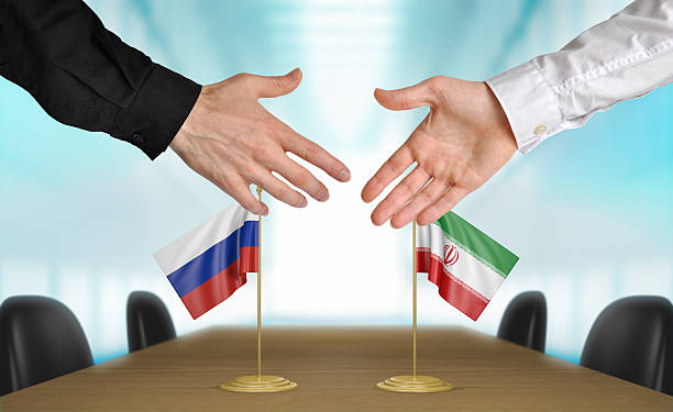 Russia and Iran diplomats agreeing on a deal Two diplomats from Russia and Iran extending their hands for a handshake on an agreement between the countries. iran stock pictures, royalty-free photos & images