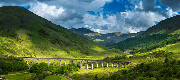 scotland sunlight on highland mountain glen glenfinnan viaduct panorama lochaber - viaduct stockfoto's en -beelden