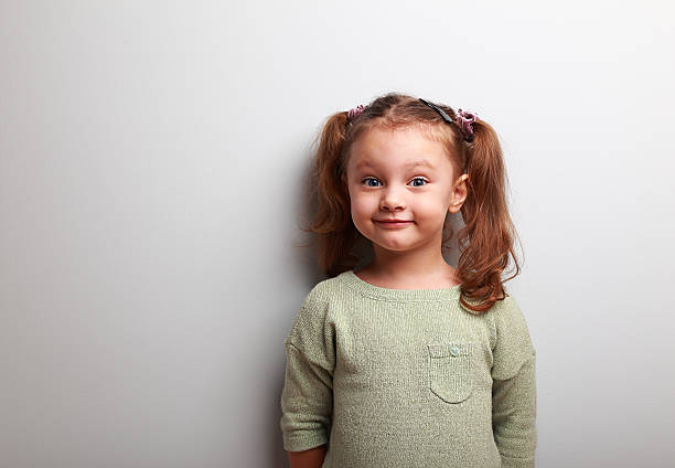 istock Happy fun girl looking with smile on blue wall background 474953514