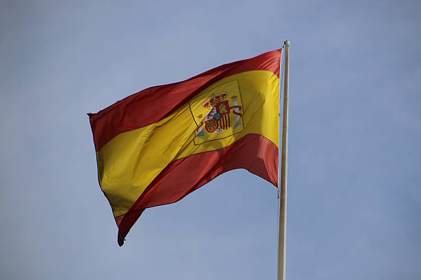 istock Spain Flag Waving in Blue Cloudscape Sky. 474957144