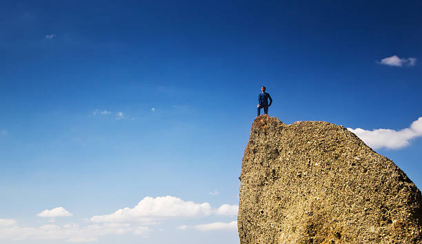 istock man on the cliff in mountains at above sea 474961818