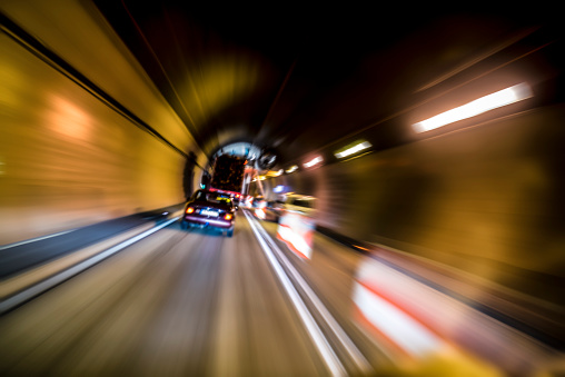 Traffic driving through the tunnel at night. Motion blur. Image is slightly tilted.