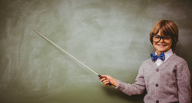 istock Boy holding stick in front of blackboard 474962952