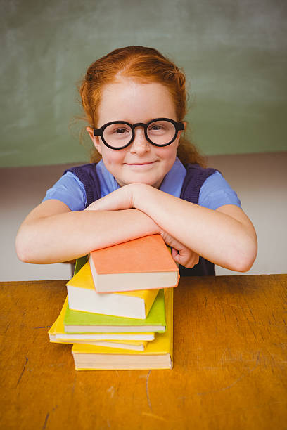 istock Cute girl with stack of books in classroom 474963132