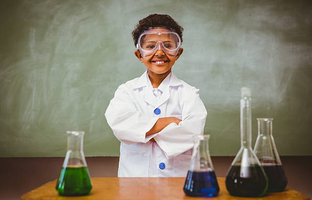 Cute boy with conical flasks in classroom Portrait of cute boy with conical flasks in the classroom scientific exploration stock pictures, royalty-free photos & images