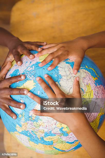 Close Up Of Hands On Globe Stock Photo - Download Image Now - 2015, 6-7 Years, 8-9 Years