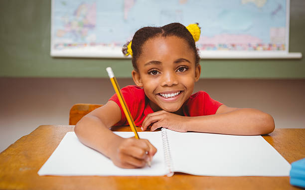istock Little girl writing book in classroom 474963948