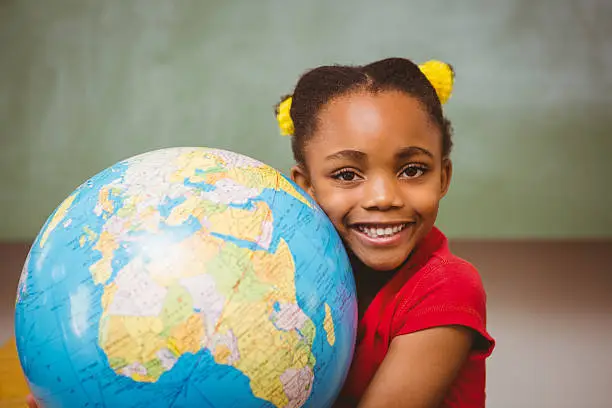 Photo of Cute little girl holding globe