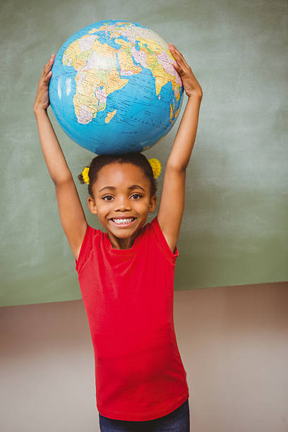 istock Little girl holding globe over head 474964038