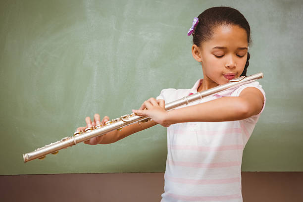 istock Little girl playing flute in classroom 474964212