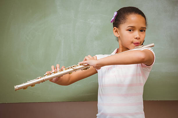 istock Little girl playing flute in classroom 474964216