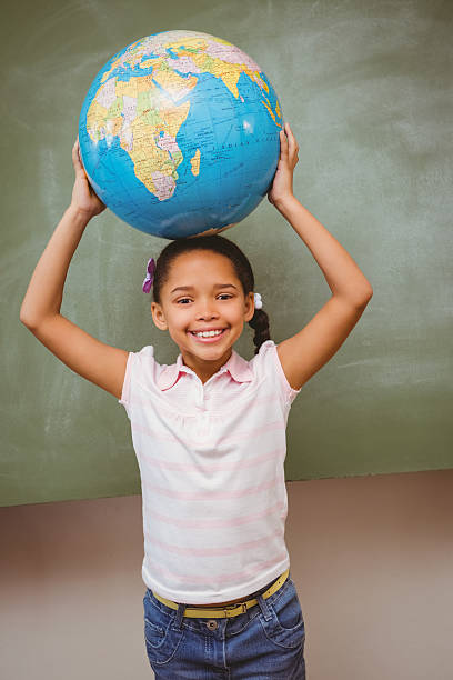 istock Cute little girl holding globe over head 474964220