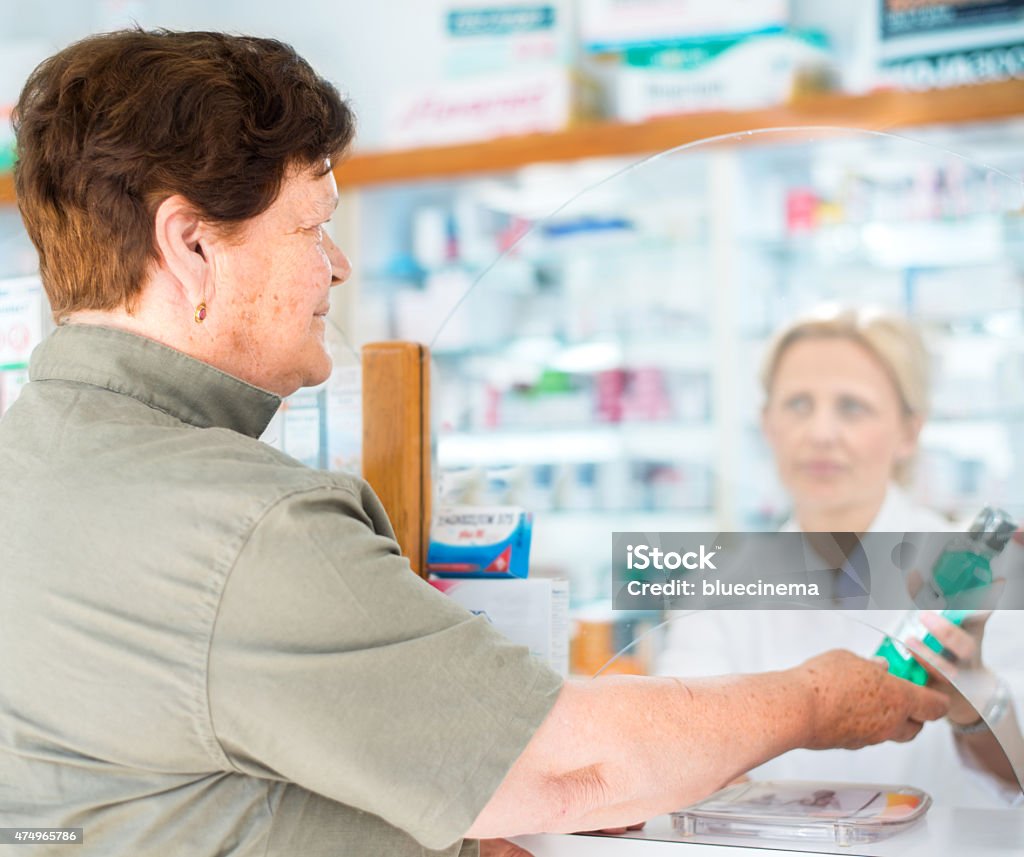 Mujer dando paquete farmacéutico del cliente - Foto de stock de 2015 libre de derechos