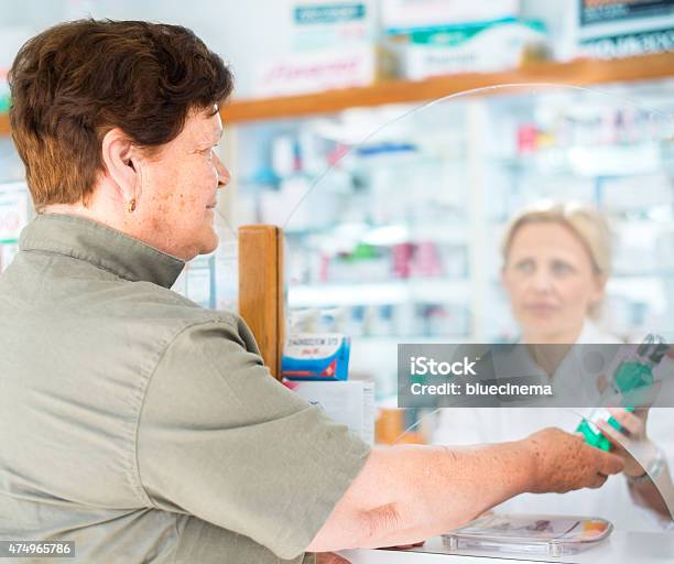 Mujer Dando Paquete Farmacéutico Del Cliente Foto de stock y más banco de imágenes de 2015 - 2015, 40-49 años, Abrigo