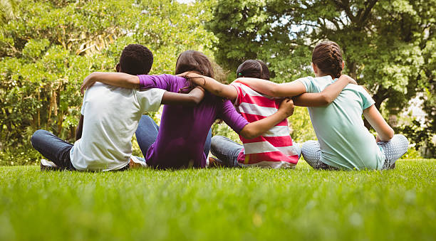 istock Children sitting with arms around at park 474966852