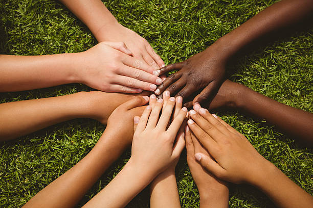 istock Children keeping hands together over grass 474966892