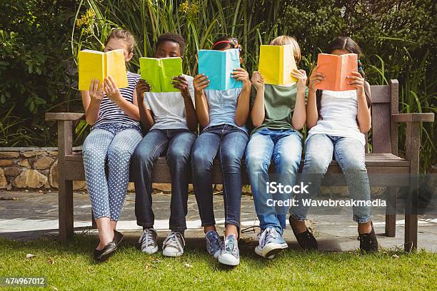 Children Reading Books At Park Stock Photo - Download Image Now - Reading, Child, Outdoors