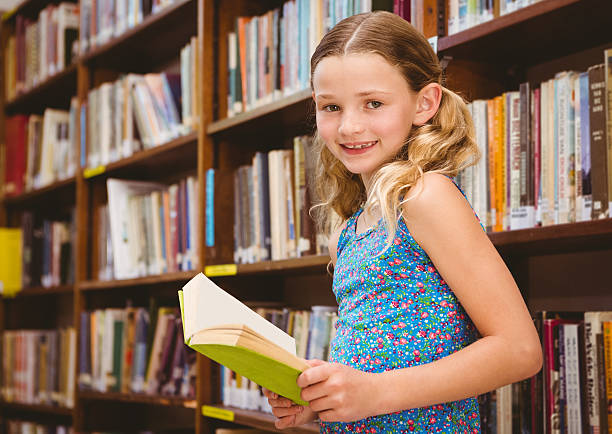 istock Girl reading book in library 474967038