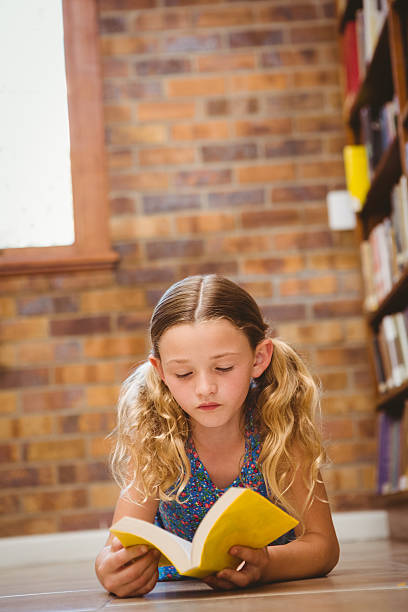 istock Girl reading book in library 474967090