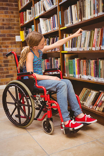 istock Girl in wheelchair selecting book 474967120