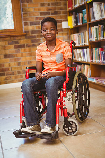istock Boy sitting in wheelchair at library 474967216