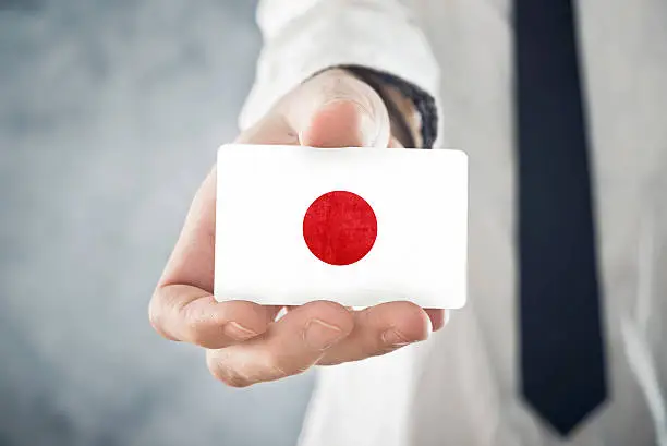 Photo of Japanese Businessman holding business card with Japan Flag