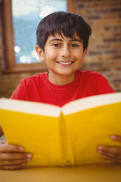 istock Portrait of boy reading book in library 474969392