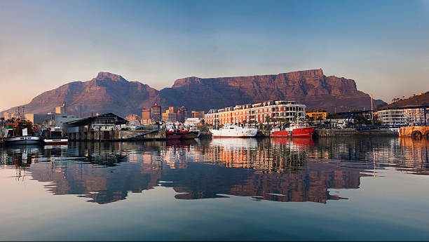 Waterfront Cape Town reflection in the morning Early morning lighting on the waterfront and Table Mountain creates a perfect reflection in the harbour water infront of it. With fishing boads in the foreground and the City of Cape Town behind the waterfront cape town photos stock pictures, royalty-free photos & images