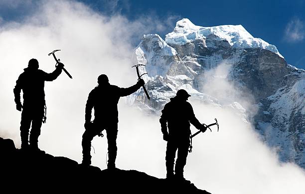 istock men with ice axe in hand and mountains with clouds 474971266