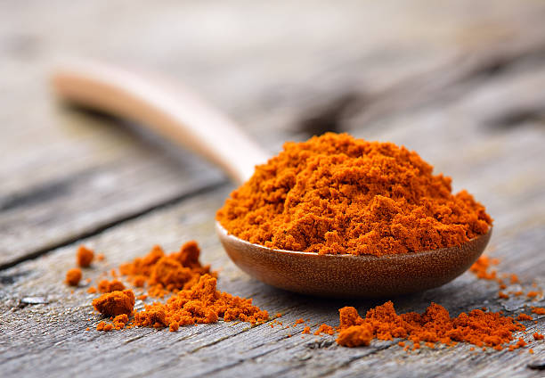 istock yellow turmeric in wooden spoon 474973710