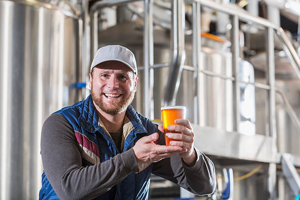 istock Man working in a small brewery holding beer 474975198