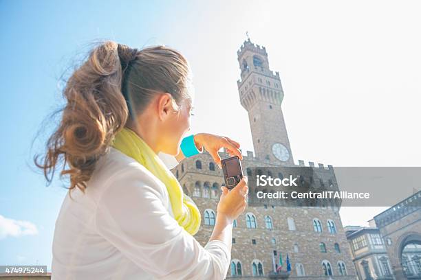 Young Woman Taking Photo Of Palazzo Vecchio In Florence Italy Stock Photo - Download Image Now