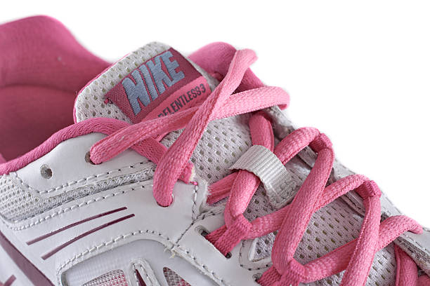 Nike women's pink running shoe - sneaker New York City, United States - May 22, 2015: Nike lady's - women's running shoe/sneaker/trainer, in gray and pink, showing the Nike Swoosh and Air logos - illustrative editorial nike air photos stock pictures, royalty-free photos & images
