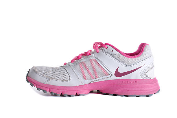 Nike women's pink running shoe - sneaker New York City, United States - May 22, 2015: Nike lady's - women's running shoe/sneaker/trainer, in gray and pink, showing the Nike Swoosh and Air logos - illustrative editorial nike air photos stock pictures, royalty-free photos & images