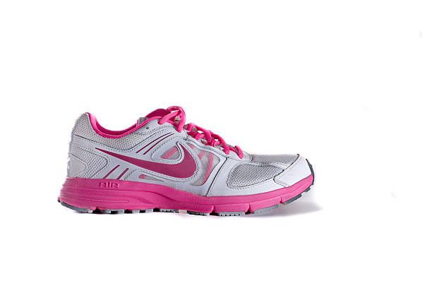 Nike women's pink running shoe - sneaker New York City, United States - May 22, 2015: Nike lady's - women's running shoe/sneaker/trainer, in gray and pink, showing the Nike Swoosh and Air logos - illustrative editorial nike air photos stock pictures, royalty-free photos & images