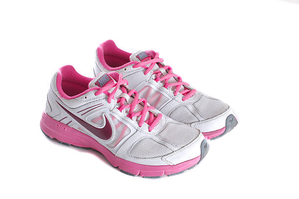 Nike women's pink running shoes - sneakers New York City, United States - May 22, 2015: Nike lady's - women's running shoes/sneakers/trainers, in gray and pink, showing the Nike Swoosh and Air logos - illustrative editorial nike air photos stock pictures, royalty-free photos & images
