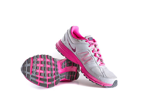 Nike women's pink running shoes - sneakers New York City, United States - May 22, 2015: Nike lady's - women's running shoes/sneakers/trainers, in gray and pink, showing the Nike Swoosh and Air logos - illustrative editorial nike air photos stock pictures, royalty-free photos & images