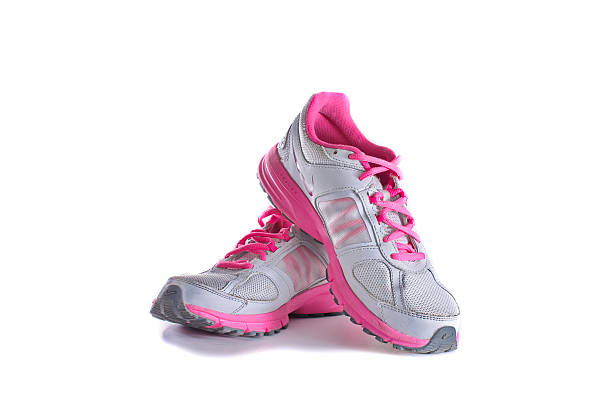 Nike women's pink running shoes - sneakers New York City, United States - May 22, 2015: Nike lady's - women's running shoes/sneakers/trainers, in gray and pink, showing the Nike Swoosh and Air logos - illustrative editorial nike air photos stock pictures, royalty-free photos & images