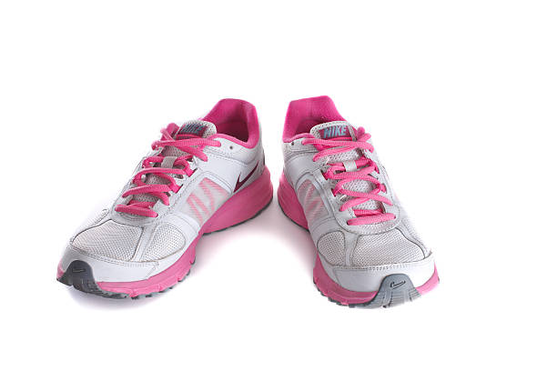 Women's pink running shoes - sneakers New York City, United States - May 22, 2015: Nike lady's - women's running shoes/sneakers/trainers, in gray and pink, showing the Nike Swoosh and Air logos - illustrative editorial nike air photos stock pictures, royalty-free photos & images