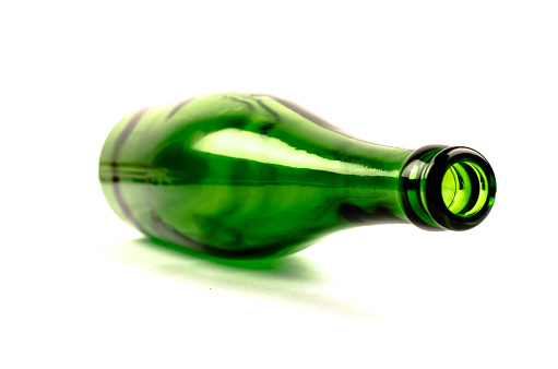 Simple empty green bottle on white background. Low depth of field. Copy space for your text. 