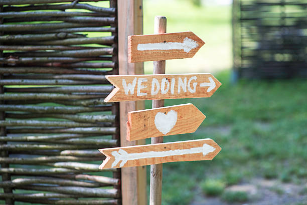 Signs outdoors with a heart, arrows and the word wedding. Would suit a catalogue of wedding gifts, the cover of a wedding album, a wedding photography site...