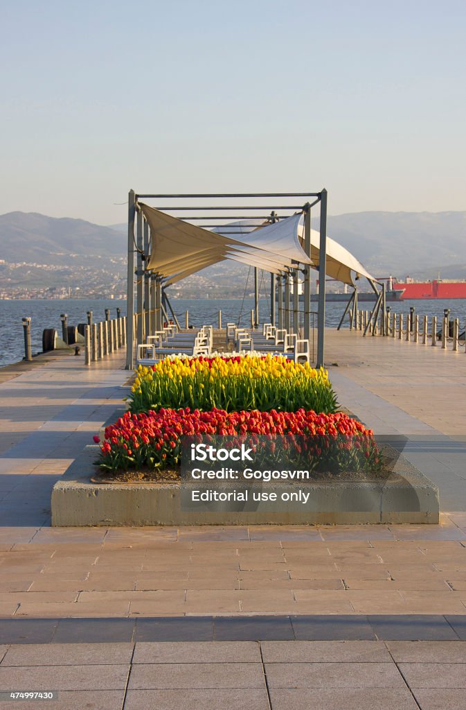 spring Kocaeli, Turkey - April 11, 2015: People walking on a pier on marmara sea in kocaeli sekapark region, Turkey. There are tulips on pier. 2015 Stock Photo