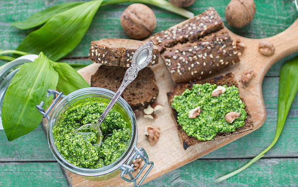 Ramson, wild garlic and sauce pesto on a wooden table Ramson, wild garlic and sauce pesto on a wooden table wild garlic leaves stock pictures, royalty-free photos & images