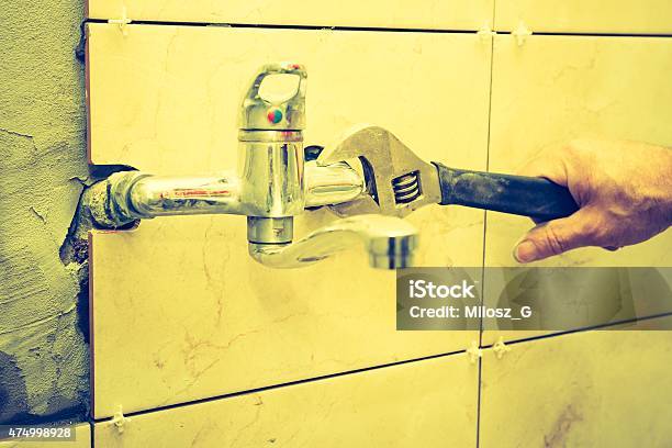 Vintage Photo Of Plumbers Hands Tightening A Water Pipe Stock Photo - Download Image Now