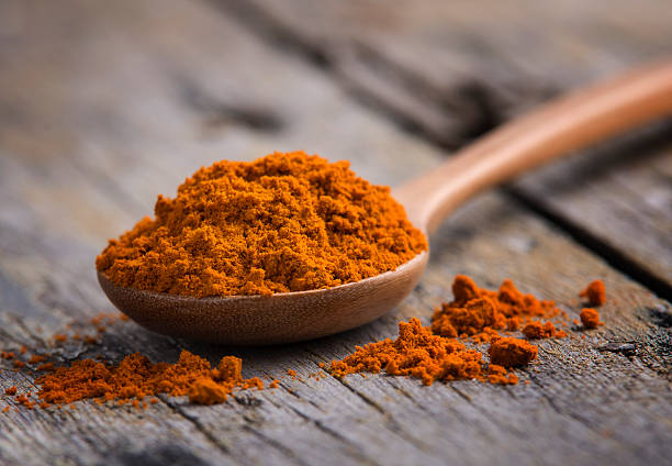istock yellow turmeric in wooden spoon 474999506