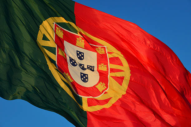 Flag of Portugal in the wind against blue sky - photograph of a Portuguese flag, NOT computer generated
