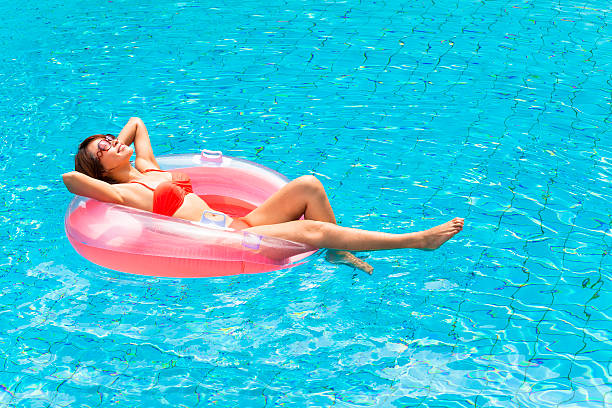 istock Young woman relaxing in swimming pool 475003938