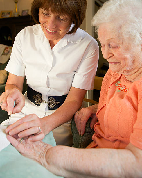 istock Care worker nurse caring for an elderly womans personal needs 475004208