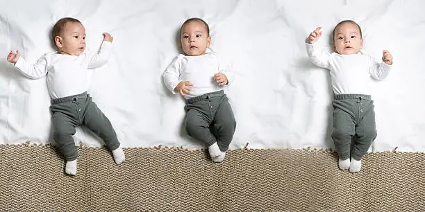 Set of poses of cute infant baby boy lying on a blanket looking at camera
