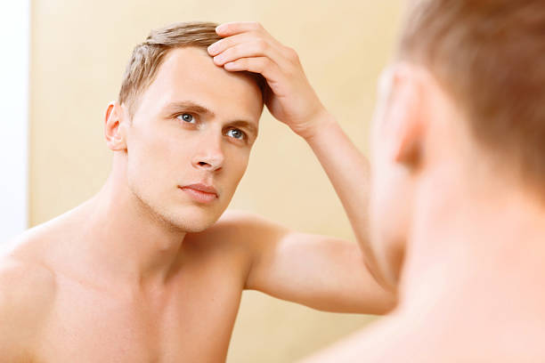 istock Topless man fixing hair in front of mirror 475012072